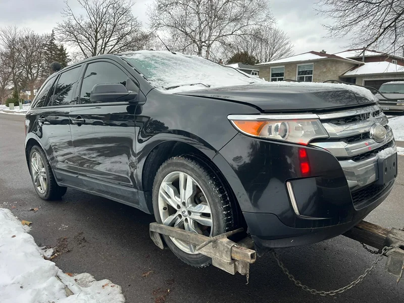 Scrap car removal in Markham: end-of-life SUV being towed from a driveway